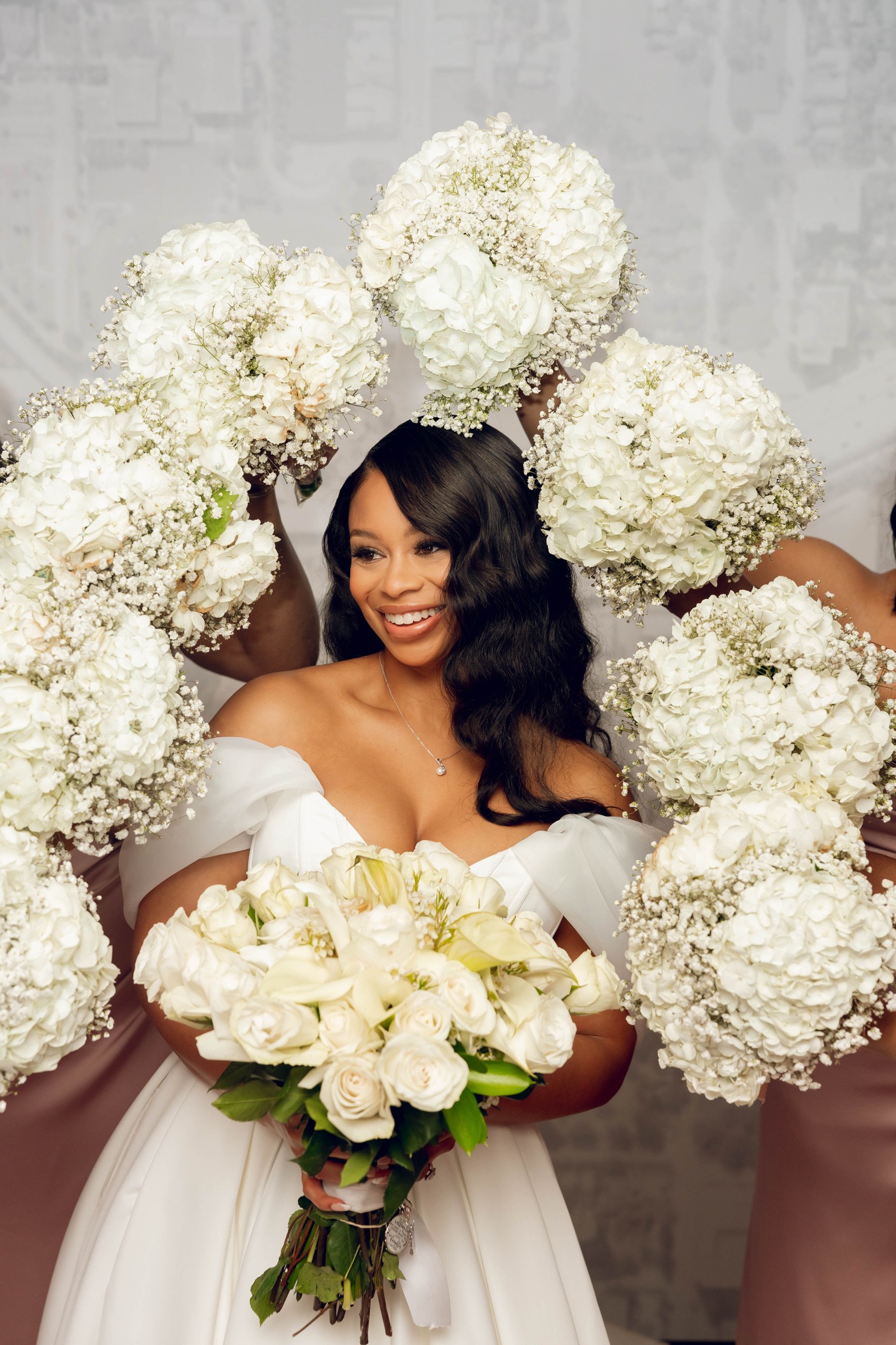 Smiling bride with white florals — hydrangea halo and bouquet