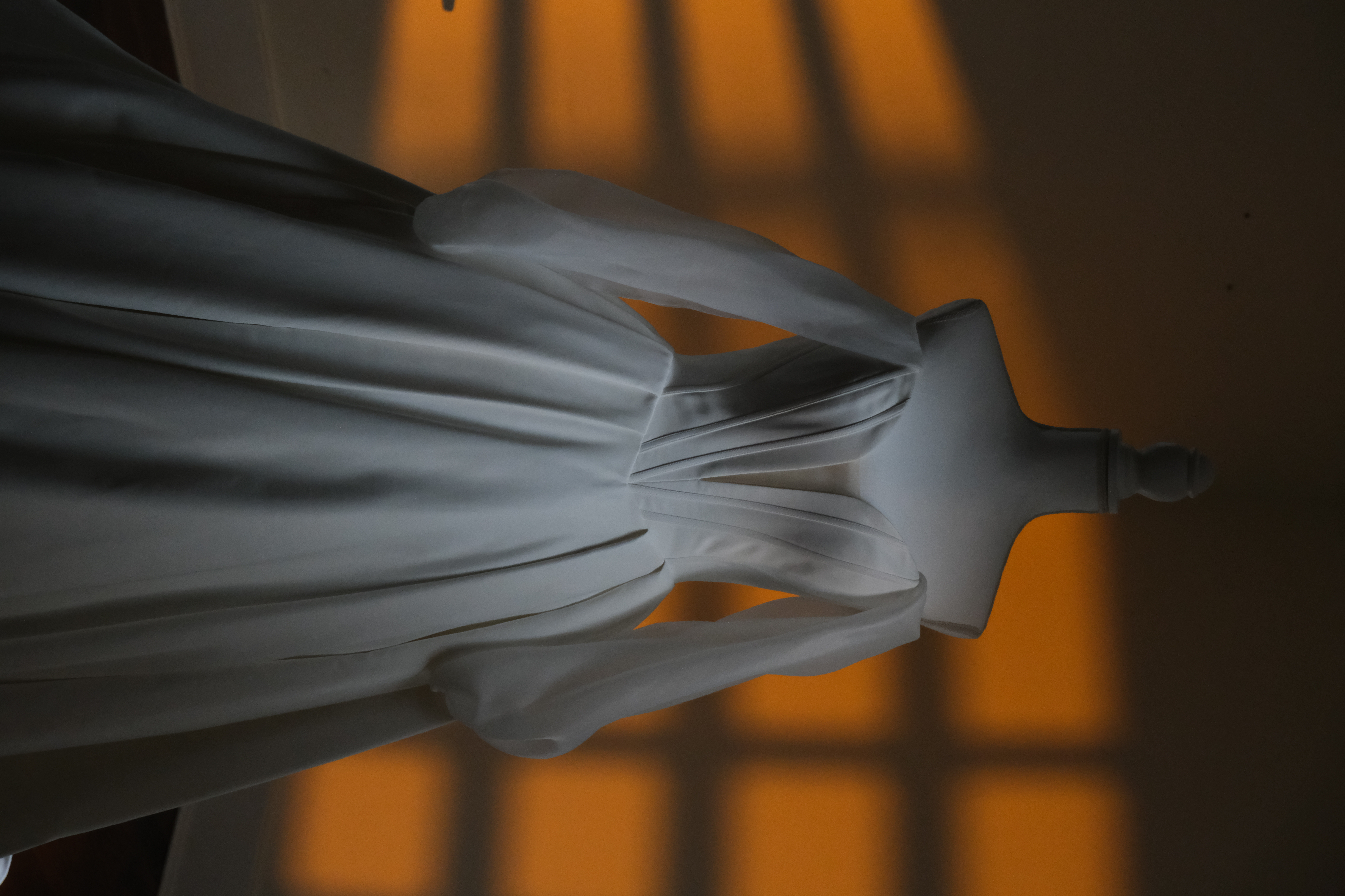 Bridal editorial — mannequin dress form, soft window light, and full-frame detail